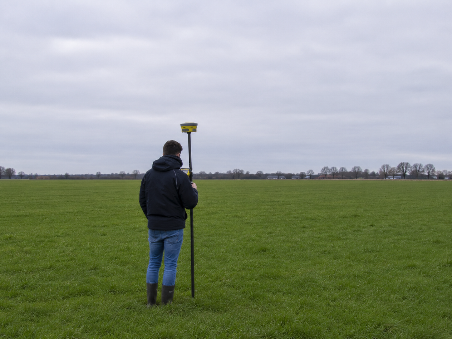 Professionele landmeter met GNSS-ontvanger in het veld
